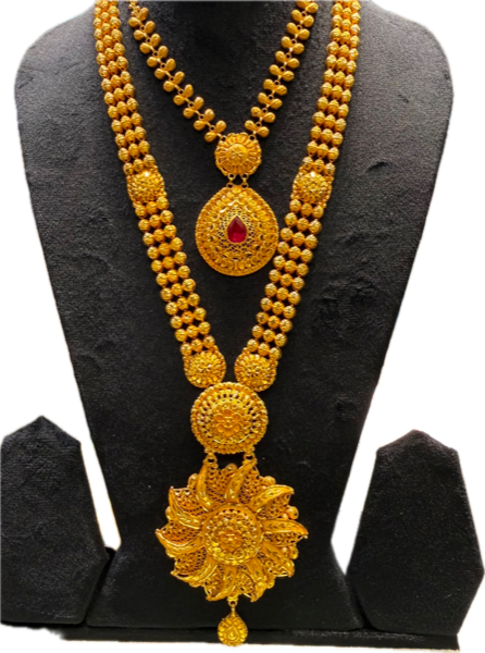 Gold necklace with a red-stone teardrop pendant and a larger lotus-shaped pendant, on a black display bust